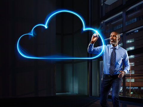 Businessman painting cloud with light