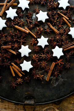 Cinnamon star cookies, cinnamon sticks and star anise on rustic baking sheet