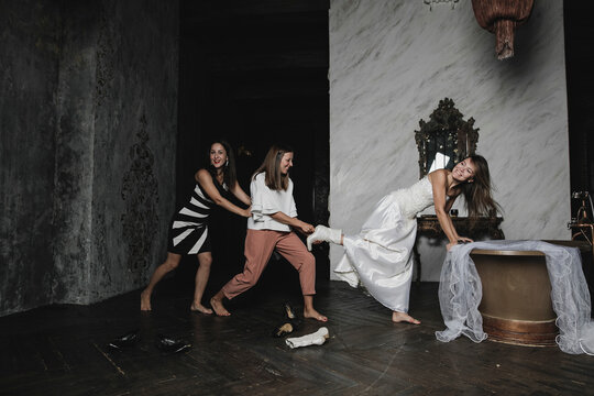 Playful friends and bride during wedding preparation