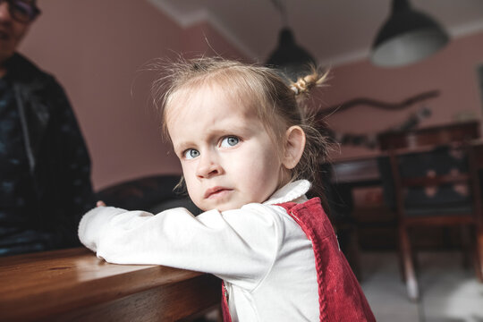Portrait of girl in living room with grandmother in background