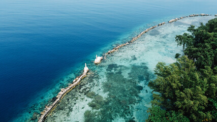 An aerial photo using a drone was taken on the coast of the 1000 island of Jakarta, Indonesia, with a calm beach atmosphere, blue sky, and clear sea water