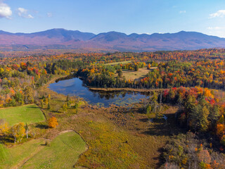 Naklejka premium aerial view of autumn forest, pond and mountain