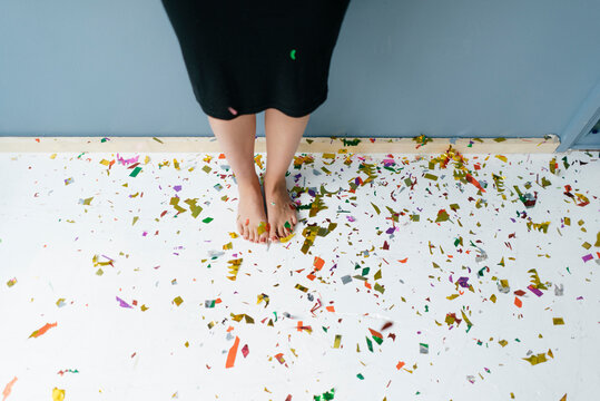 Woman standing on confetti with bare feet