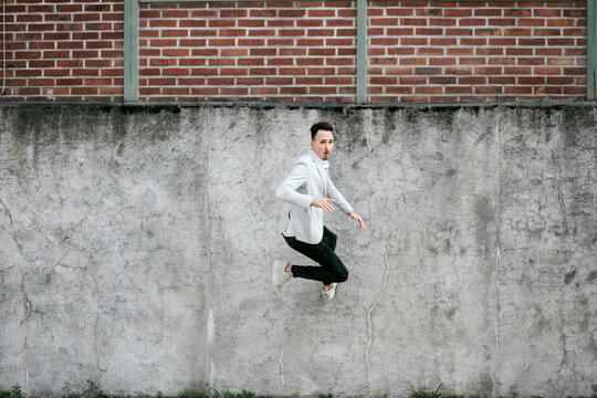 Businessman jumping on a wall