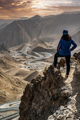 A female hiker stands at the peak and look down