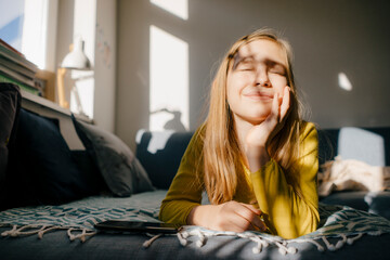 Girl lying on couch at home in sunshine
