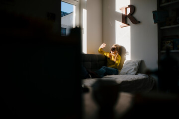 Girl at home shielding her eyes from sunshine