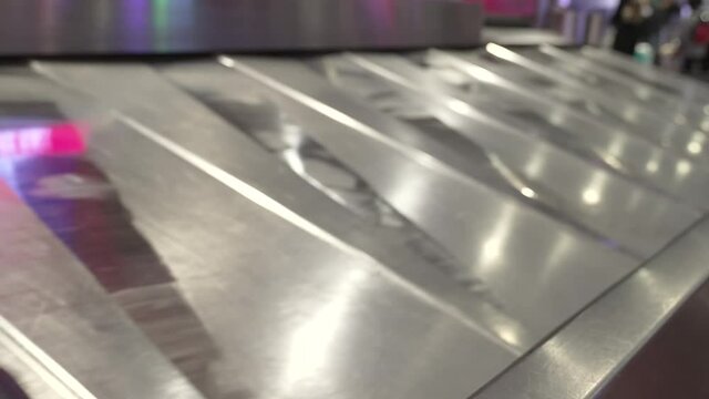 This video  shows a busy luggage conveyor belt circulating suitcases at an airport baggage claim.
