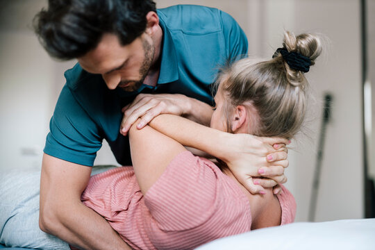 Physiotherapist giving treatment to female patient