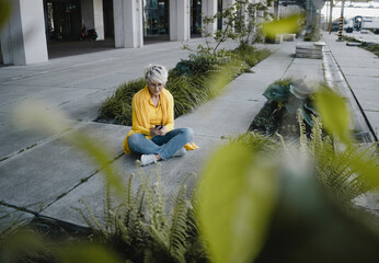 Mature woman using smartphone outdoors
