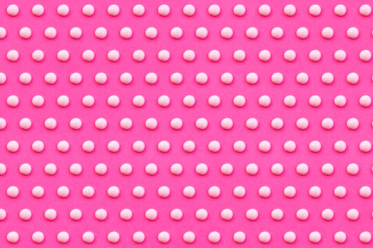 Pattern of white liquid drops against vibrant pink background