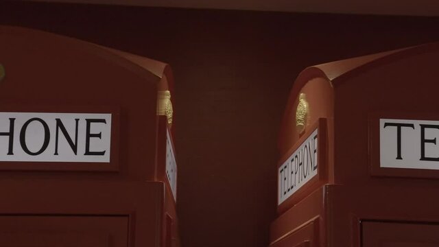 This panning video shows a row of traditional red telephone booths.