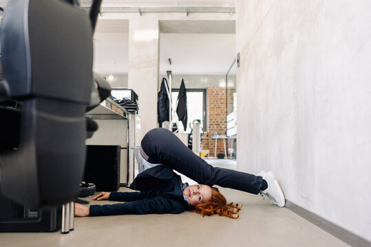 Businesswoman lying on the floor in office exercising