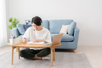 Fototapeta premium パソコンを見て勉強する若い男性・オンライン授業