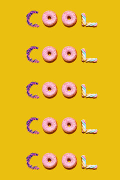Pattern of doughnuts, marshmallows and sugar sprinkles arranged into single repeated word