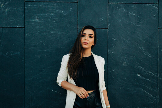 Portrait of young woman in front of black wall
