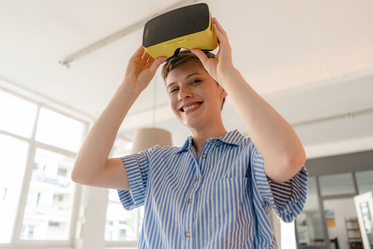 Portrait of smiling businesswoman with VR glasses in office
