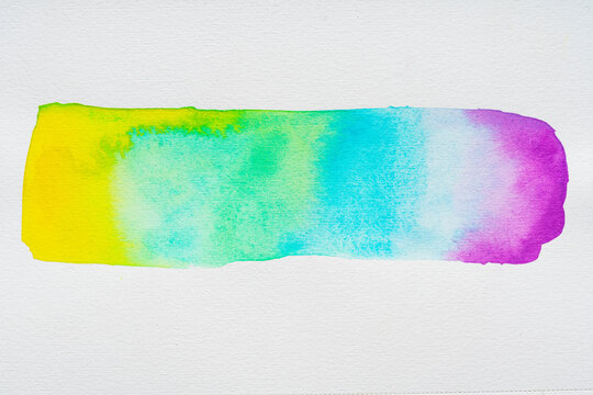 Rainbow watercolor paint gradient brush stroke on white paper