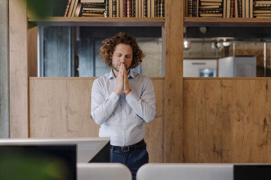 Portrait of serene businessman meditating in office