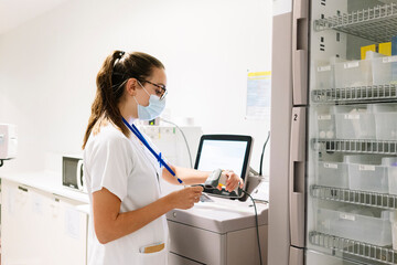 Female doctor scanning id card while standing in pharmacy at hospital