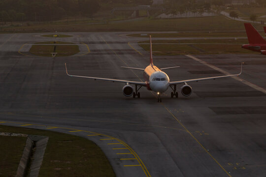 Commercial airplane at airport at sunset