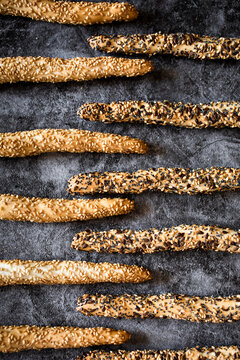 Studio shot of fresh Italian grissini breadsticks with sesame, flax and poppy seeds