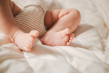 Soft focus close-up of newborn baby feet on a white blanket.
