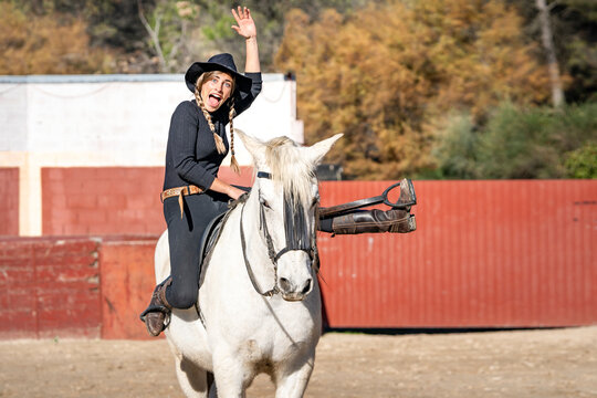Portrait of woman horseback riding in paddock