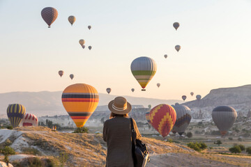 Young woman and hot air ballons, Goreme, Cappadocia, Turkey