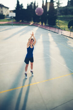 Teenage Player Taking Shot At Scoring Basketball On Court