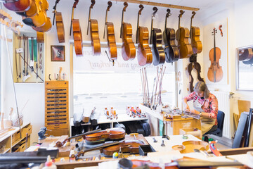 Female violin maker at work in her workshop