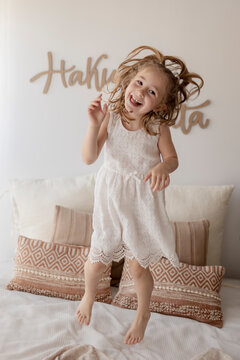 Portrait of happy little girl jumping on bed