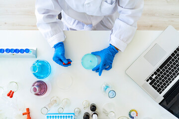 Female researcher's hands mixing solution through pipette at chemistry lab