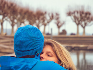 Man with blue woll cap embracing blond woman