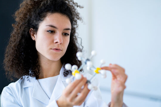 Female researcher examining molecular structure at chemistry lab