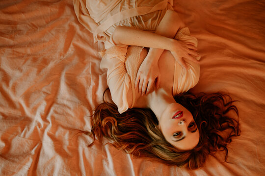 Portrait of attractive blond woman lying in bed