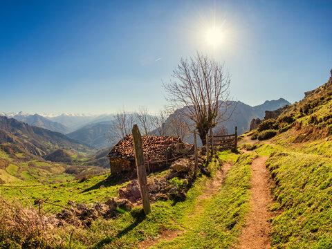 Spain, Asturia, Collada de Pelugano, ston hut at hiking trail against the sun