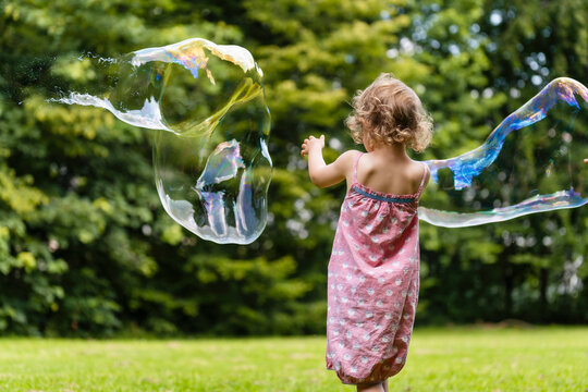 Girl playing with bubbles at park