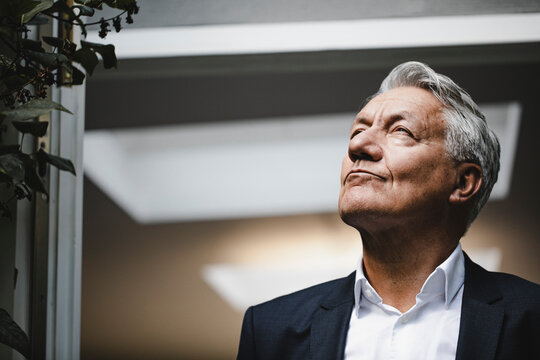 Successful businessman looking up in satisfaction