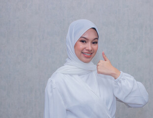 Muslim girl smiling happily on plain background