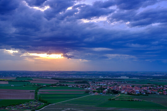 Storm clouds over village and vineyard against sky at dusk
