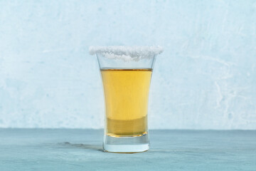 Gold tequila shot with a salt rim, a Mexican drink, side view