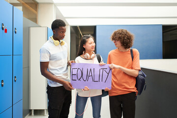 Group of students of different ethnicities carrying a banner at school protesting for equality.
