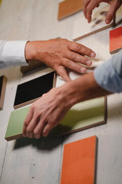Hands of architects choosing colour samples in office