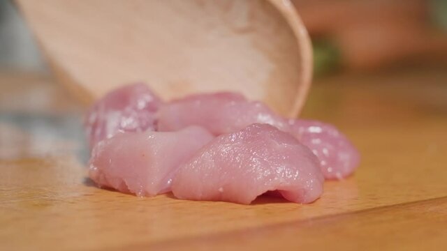 Super Slow Motion Of Uncooked Young Lamb Meat On Chopping Board Pushed By A Wooden Spoon. close up