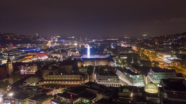 Moving aerial night time lapse in 4k of downtown skyline in the city of Stuttgart, Germany from left to right with Ferris wheel.