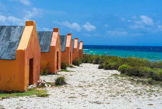 Slave huts at beach against blue sky during sunny day, Bonaire, ABC Islands, Caribbean Netherlands