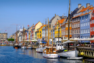 Denmark, Copenhagen, Boats moored along Nyhavn canal with colorful townhouses in background