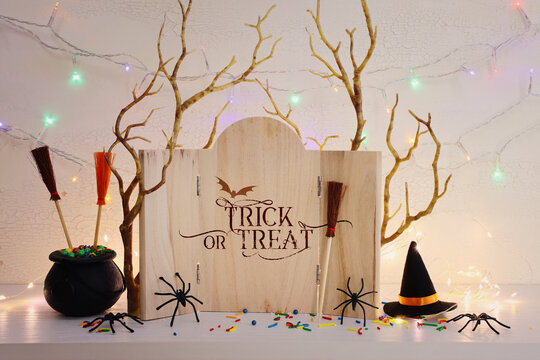 holidays image of Halloween. spiders, bare trees and wooden board frame with text