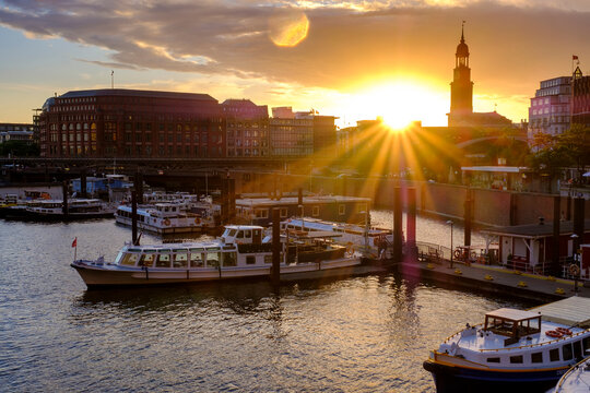 Germany, Hamburg, Boats moored in city harbor at sunset